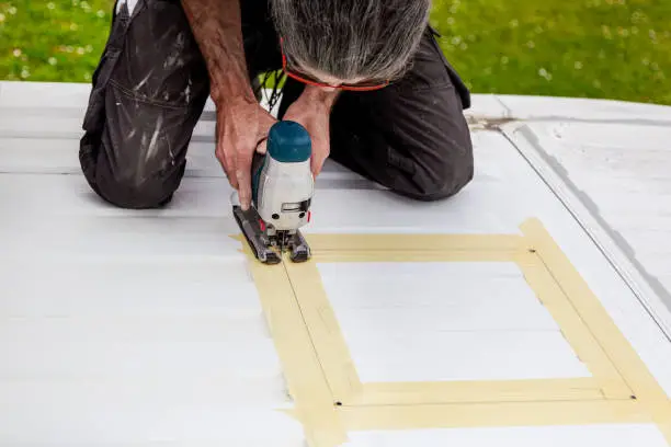 DIY Camper Jumper van conversion. new window outside. cutting with an electric jigsaw. preparation for installing a top window.